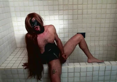 Long Hair Sissy in Corset Uses Gagball in Bathroom